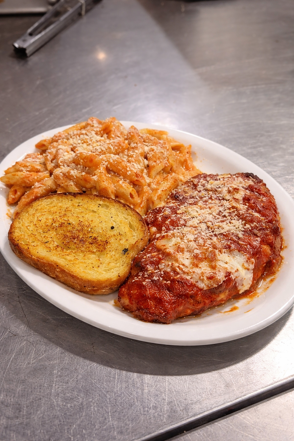 Veal Parmigiana with pasta rose and garlic bread
